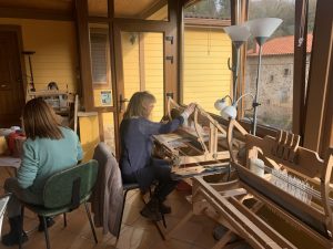 alumnas utilizando el telar en una clase de taller de telar bajo lizo en tamaño grande